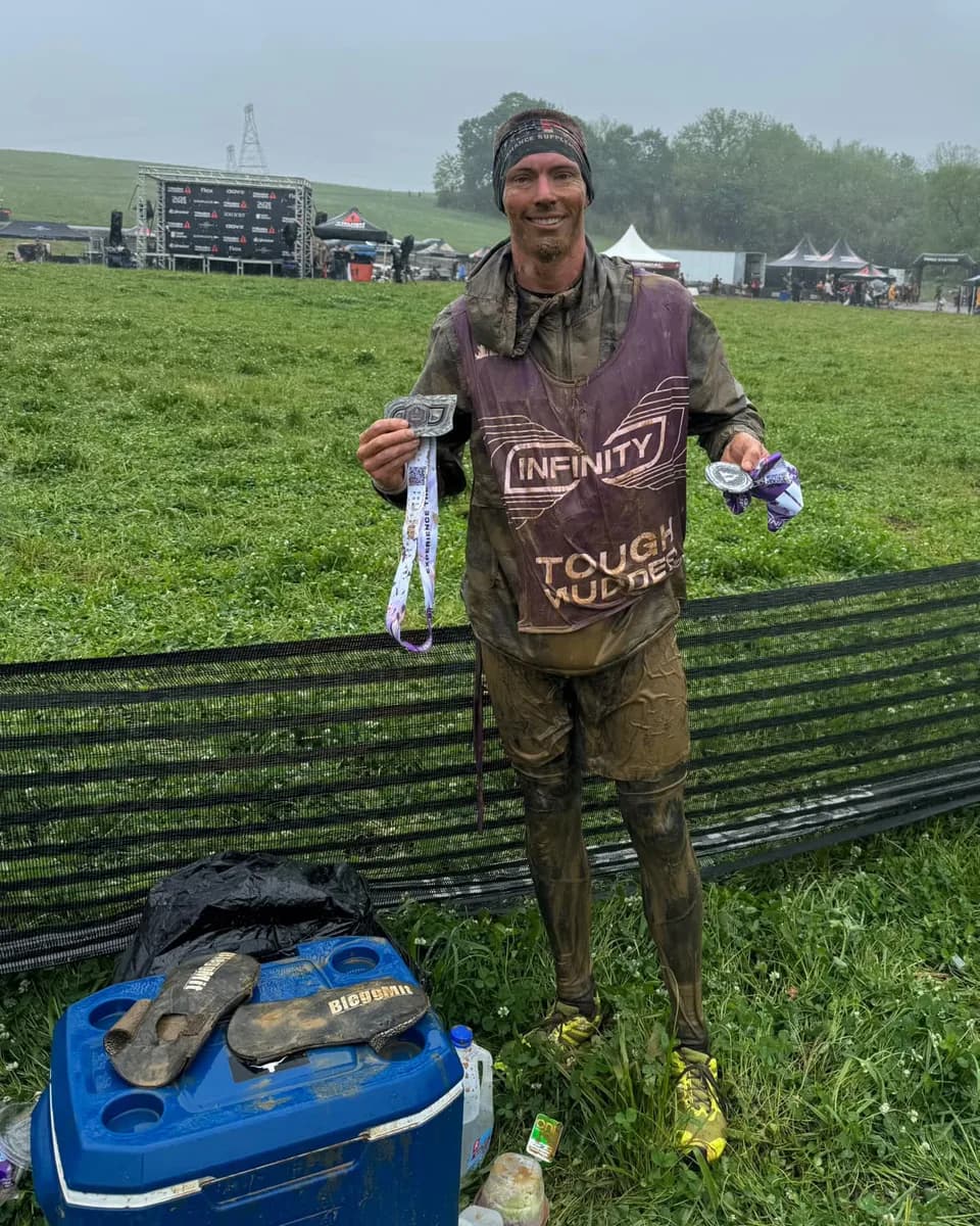 Brent Becher holding his medals at Tough Mudder Infinity